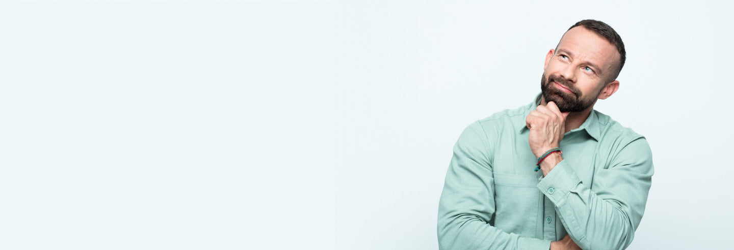 Man with head cocked and his hand under his chin thinking