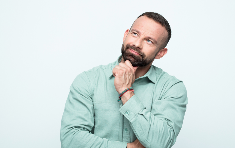 Man with head cocked and his hand under his chin thinking
