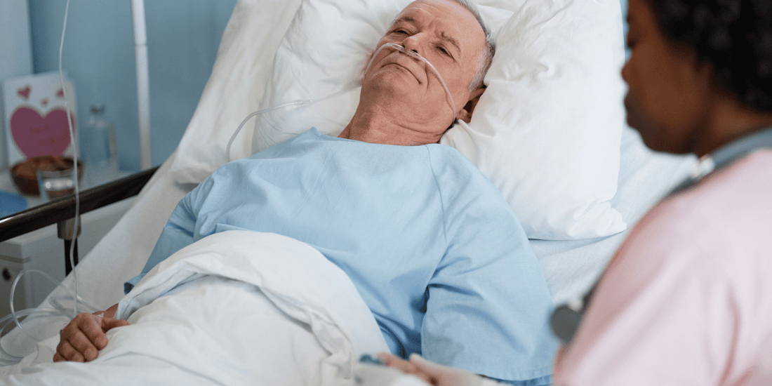 A man recovering in a hospital bed after a prostatectomy, attended by a nurse providing care and support.