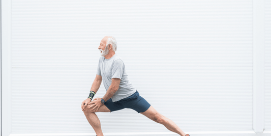 An elderly man performing a yoga pose, showcasing his strength and focus in a calm environment.