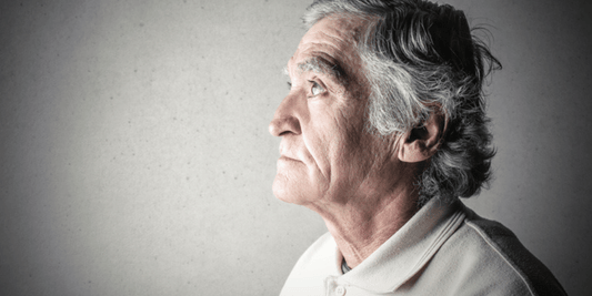 An older man gazes thoughtfully into the distance, reflecting on memories or future possibilities.