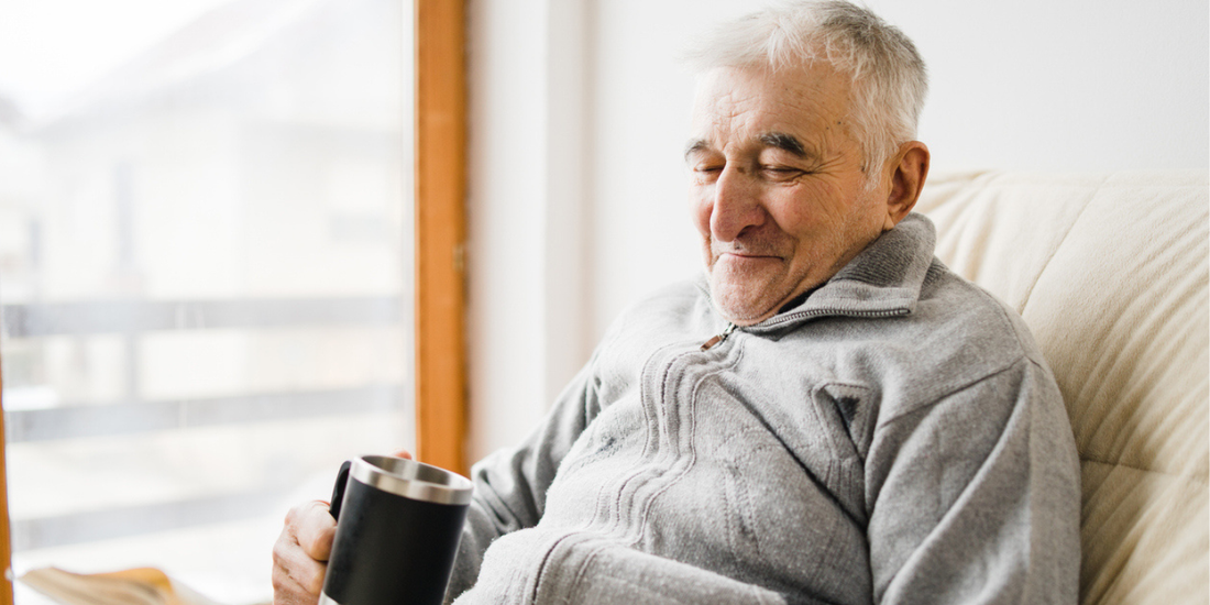 Older man relaxing at home during recovery after prostate surgery.