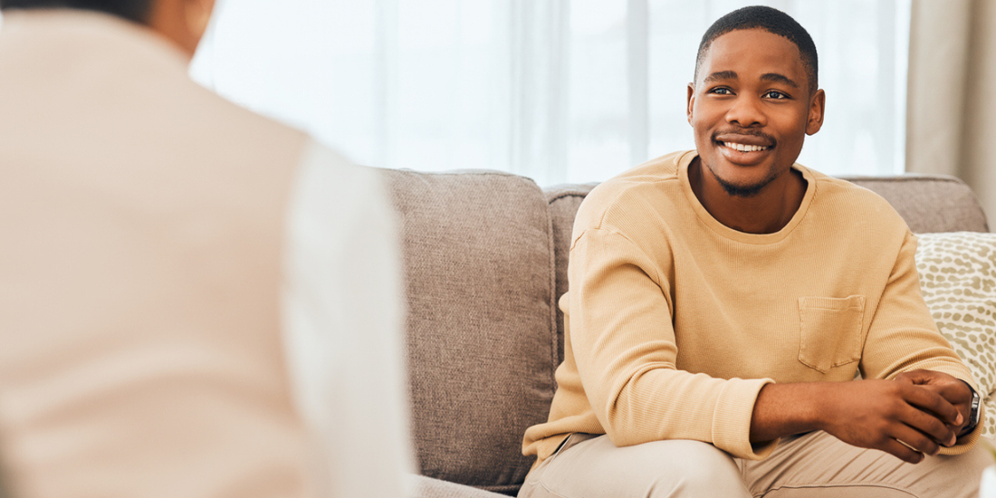 Man having a relaxed conversation at home while discussing erectile dysfunction support and treatment options.