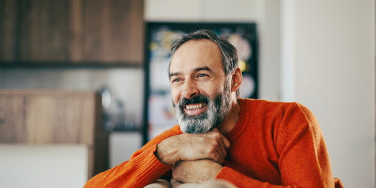 Smiling man over 50 at home, representing realistic erectile dysfunction support and treatment options.