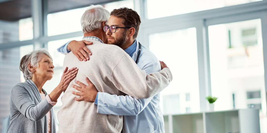 Older man receiving support from his doctor and partner during a prostate cancer consultation, illustrating care around treatment and sexual side effects.