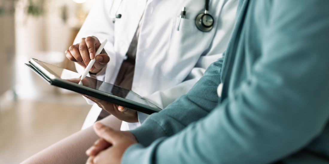 Doctor reviewing treatment information with a patient, illustrating a discussion about erectile dysfunction after prostate radiotherapy or surgery.