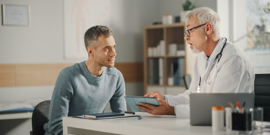 Man discussing recurring erection problems with a doctor during a private medical consultation.
