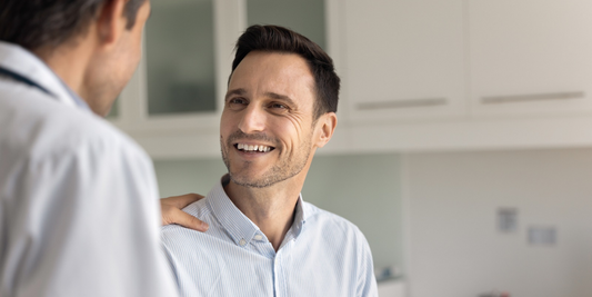Smiling man speaking with a healthcare professional during a consultation about erectile dysfunction treatment.