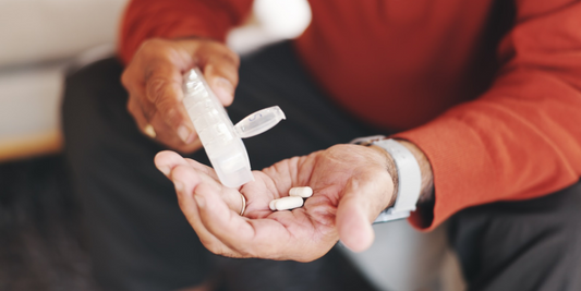Man holding daily medication capsules in his hand, representing regular treatment as part of an erectile dysfunction management routine.