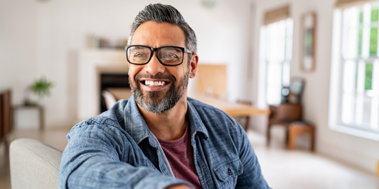 Smiling middle-aged man at home, representing confidence and wellbeing while considering erectile dysfunction support options.