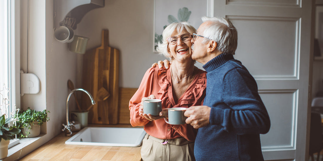 Elderly couple cuddling in kitchen