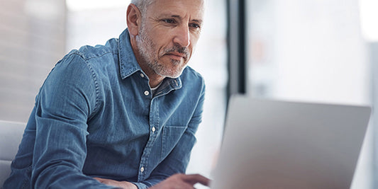 Middle aged man staring at a laptop