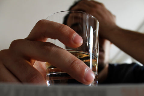 Man holding glass of filled with alcohol