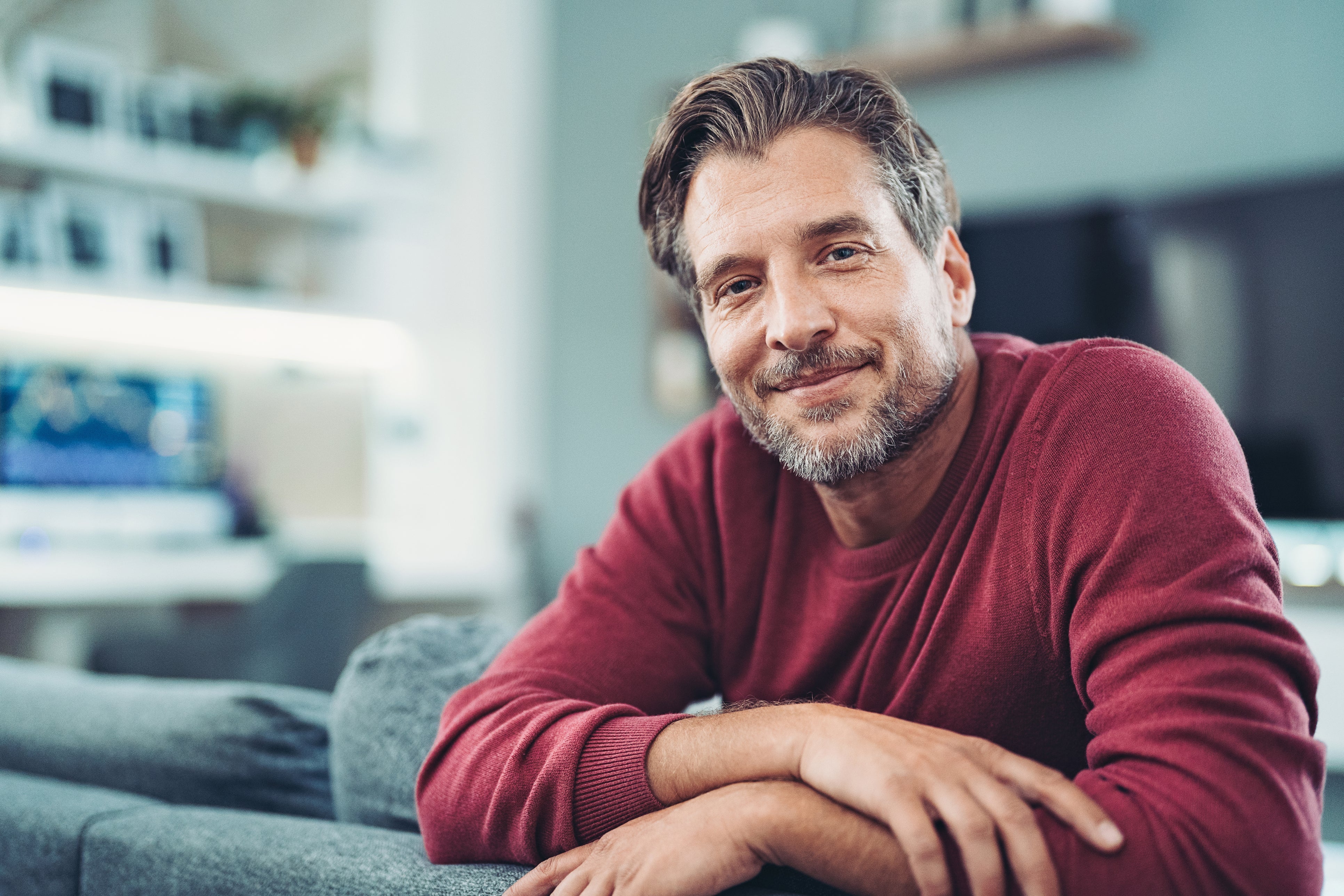 A man sitting on a couch confidently smiling