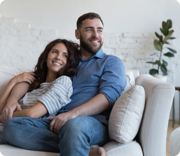 A couple cuddling on a couch