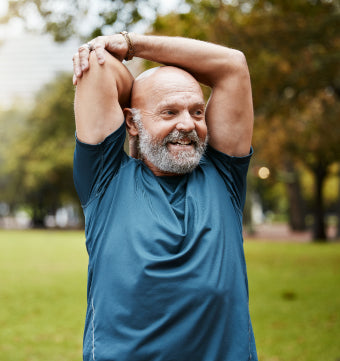 Man smiling while stretching at the park