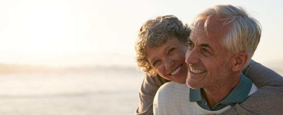 An older couple embracing on the beach