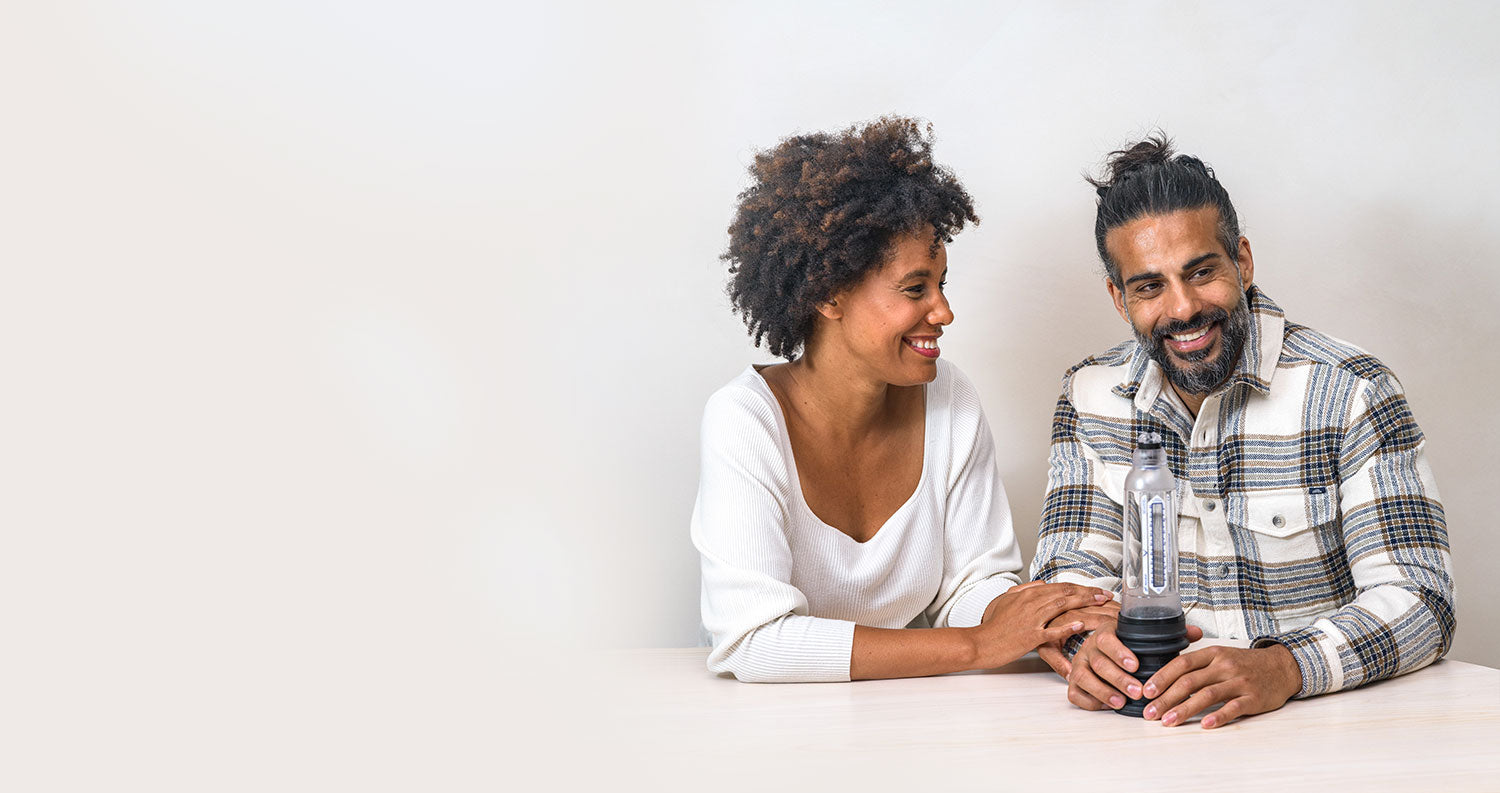 Man holding Vaxaid Penis pump on a table while wife looks at him