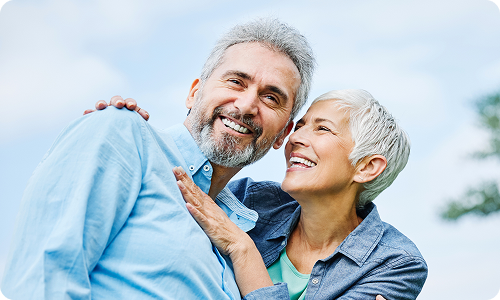 An older couple holding each other smiling